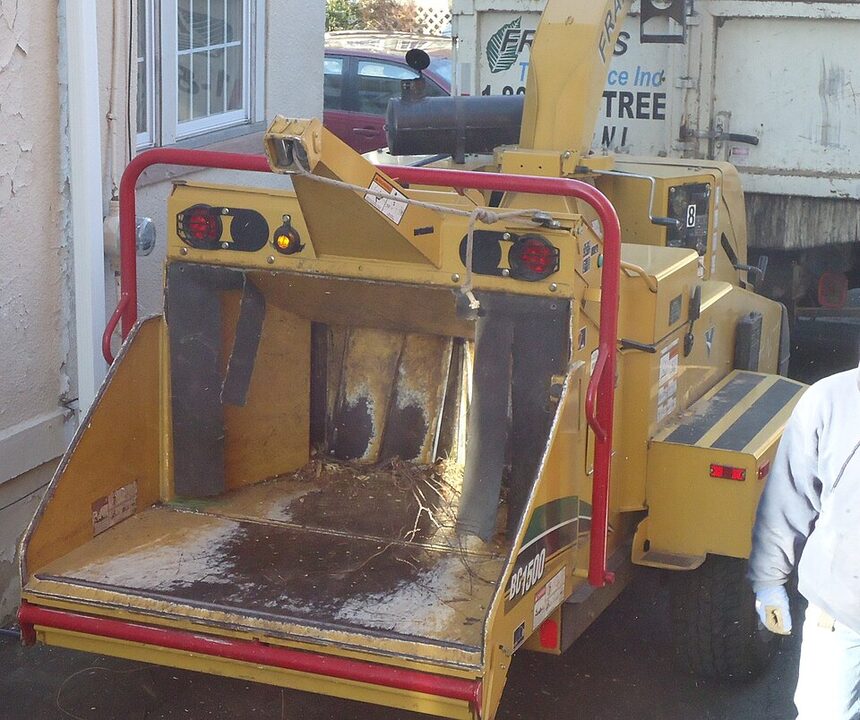 Wood chipper turning branches into mulch for haul-away