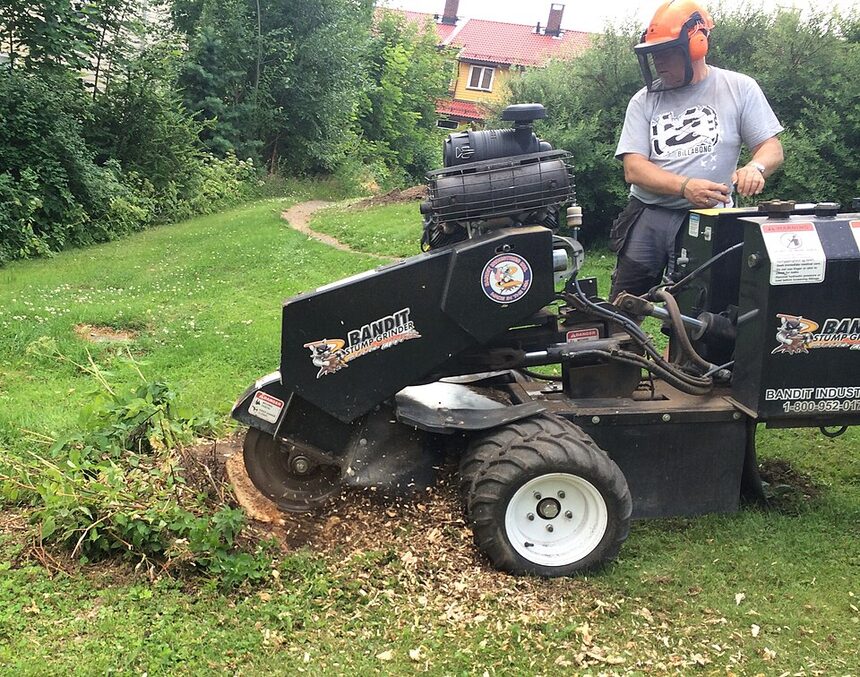 Operator on a ride-on stump grinder clearing a yard